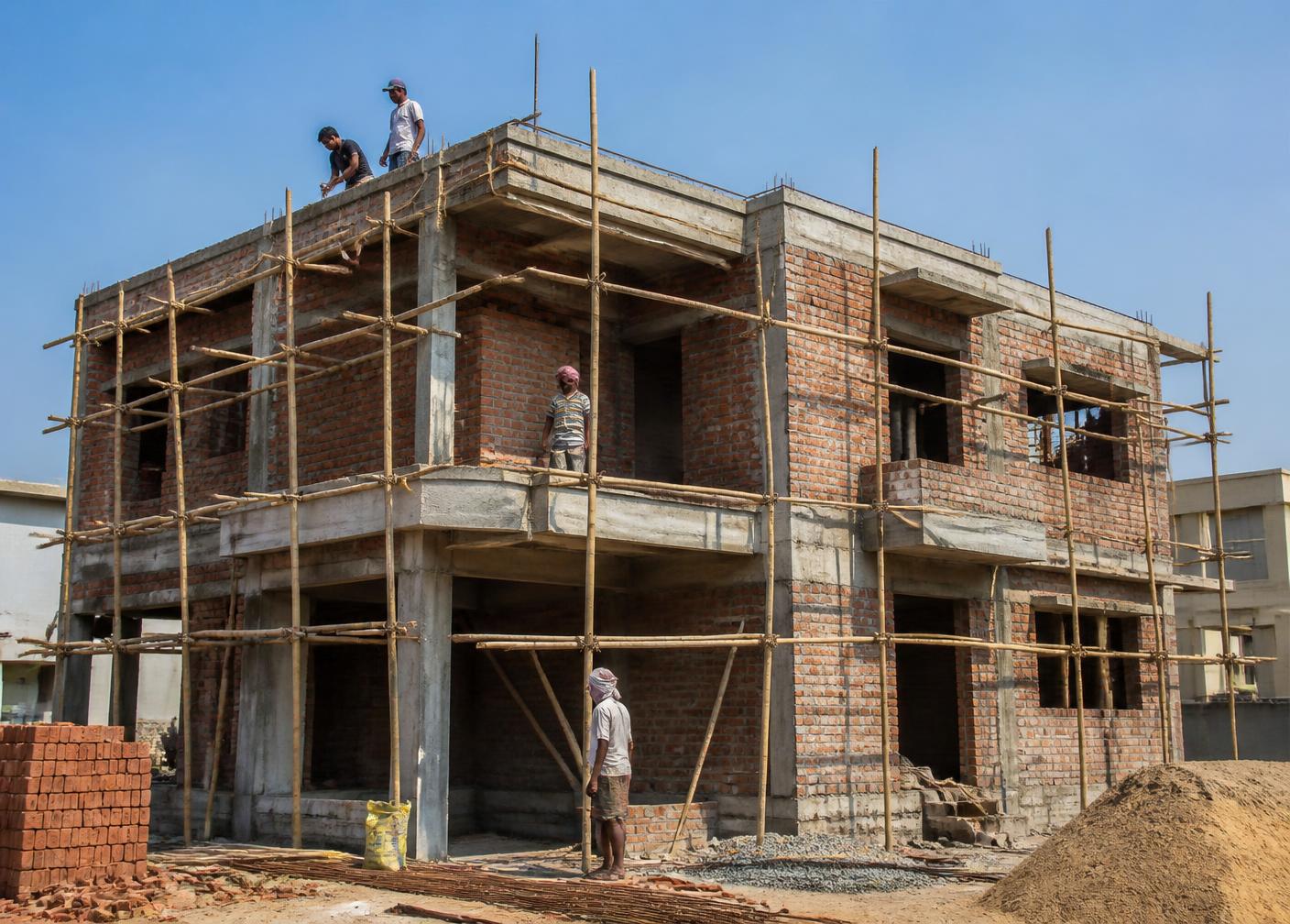 House under construction with concrete frame and brickwork